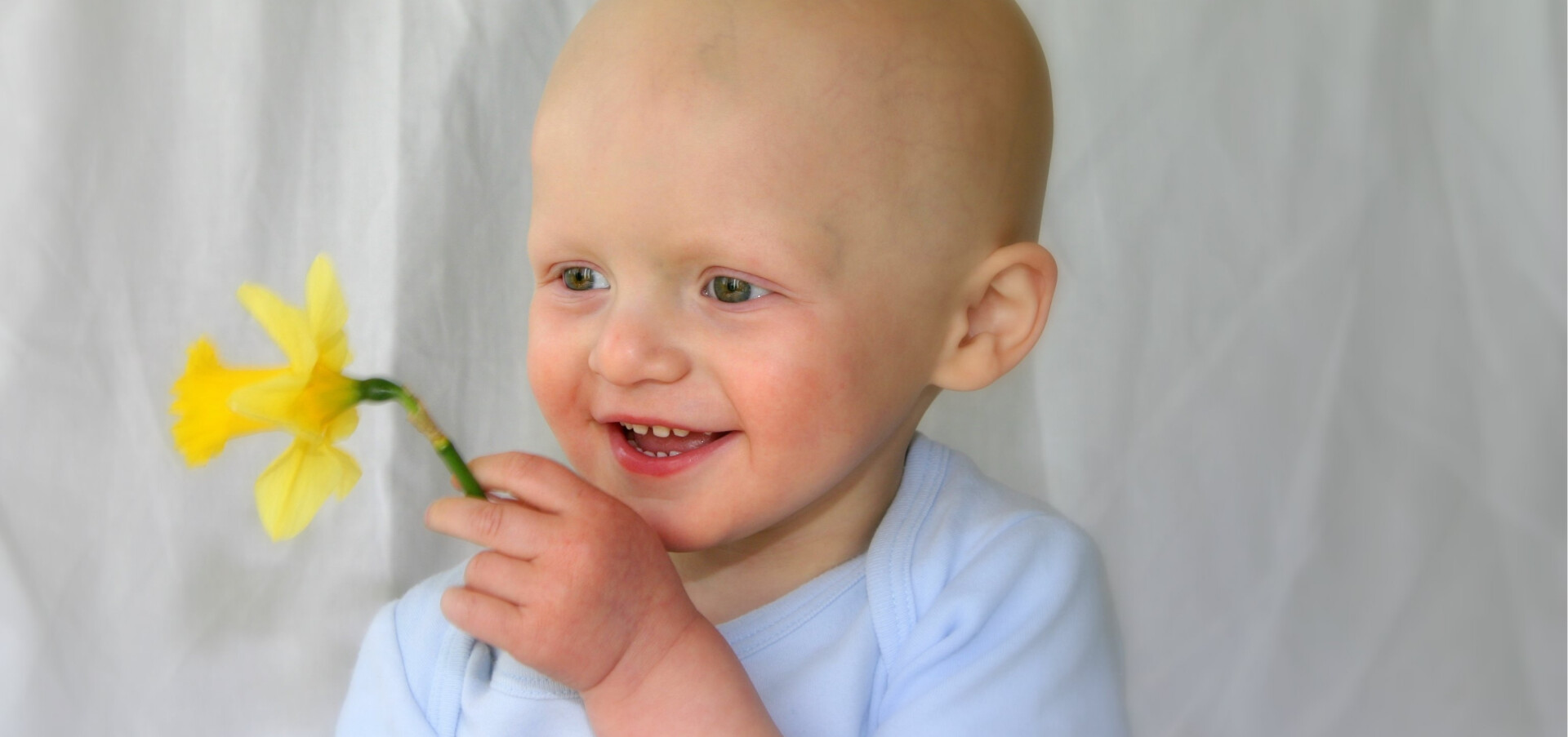 Glatt barn som får hjälp i kampen mot barncancer.