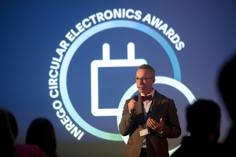 Vd Henrik Nilsson på scen framför Inrego Circular Electroncis Awards logga.